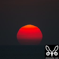 西表島の横に沈む夕陽。